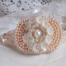 Bracelet Bouquet d'un Jour brodé avec un cabochon rond couleur Ivoire, fleurs en Lucite entrelacées avec des rocailles, toupies en Cristal et Light Peach de qualité AB2X à laquelle s'ajoute des rubans